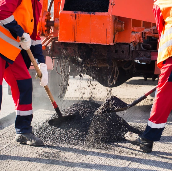 Workers laying asphalt pavement