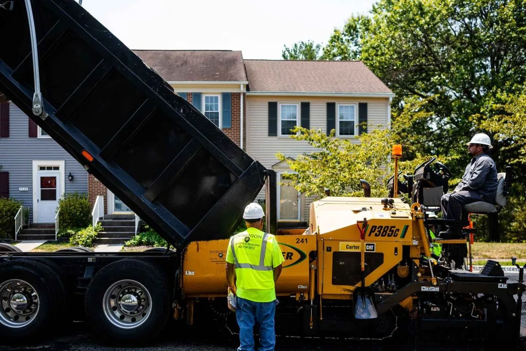 Dump Truck Dumping Asphalt Into a Weiler